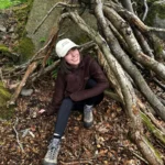 Wearing the cream cap in a woodland den