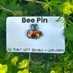 The bee pin on its backing card