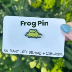 The frog pin on its backing card